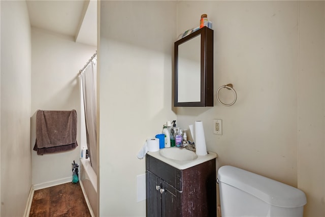 full bathroom featuring shower / bathtub combination with curtain, hardwood / wood-style floors, vanity, and toilet