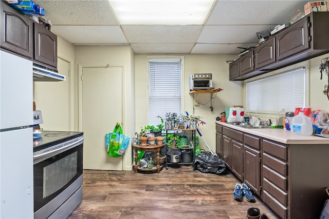 kitchen with dark brown cabinets, stainless steel electric range oven, a drop ceiling, and hardwood / wood-style floors