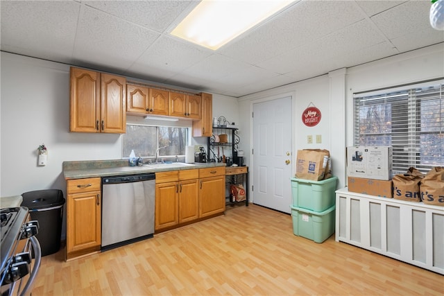 kitchen with appliances with stainless steel finishes, a paneled ceiling, light hardwood / wood-style floors, and sink