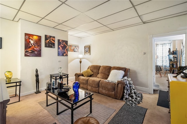 living room with a paneled ceiling and light colored carpet