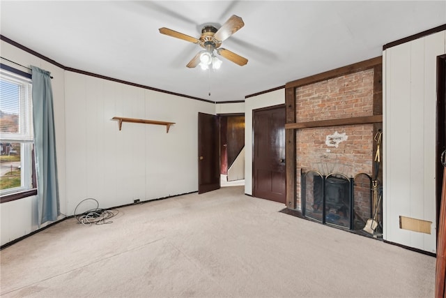 unfurnished living room with light carpet, crown molding, ceiling fan, and a brick fireplace