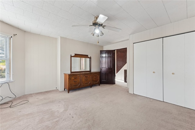 unfurnished bedroom featuring ceiling fan and light carpet