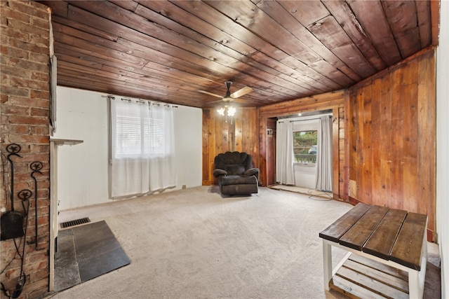 unfurnished room featuring carpet flooring, ceiling fan, wooden ceiling, wooden walls, and a fireplace