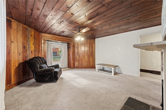 sitting room with light colored carpet, ceiling fan, wooden ceiling, and wood walls