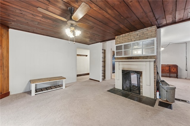 unfurnished living room featuring ceiling fan, wooden ceiling, carpet floors, and wooden walls