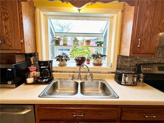 kitchen featuring backsplash, sink, and appliances with stainless steel finishes