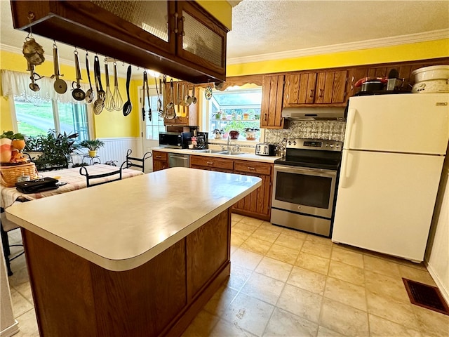 kitchen featuring crown molding, sink, stainless steel appliances, and a textured ceiling