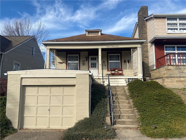 view of front of property featuring a porch and a garage