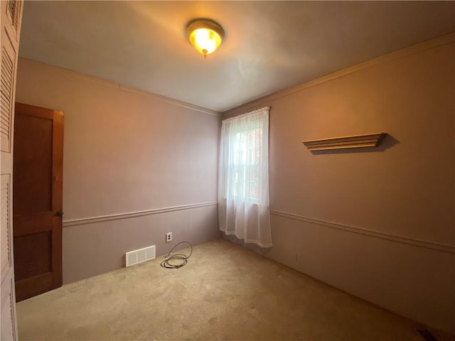 carpeted empty room with crown molding