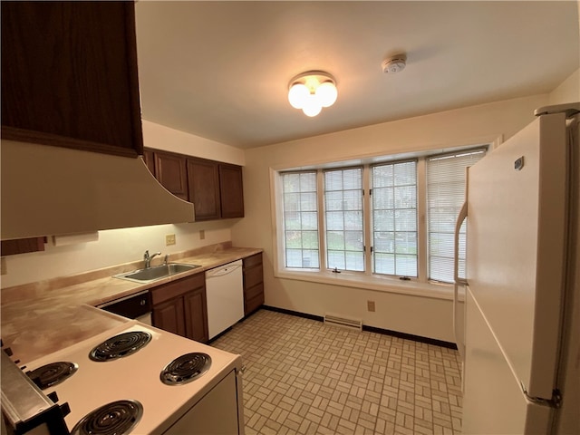 kitchen with dark brown cabinetry, white appliances, sink, and light tile patterned floors