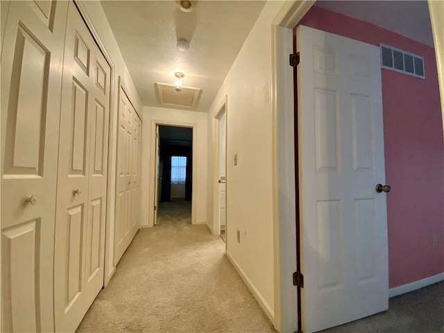 corridor featuring light colored carpet