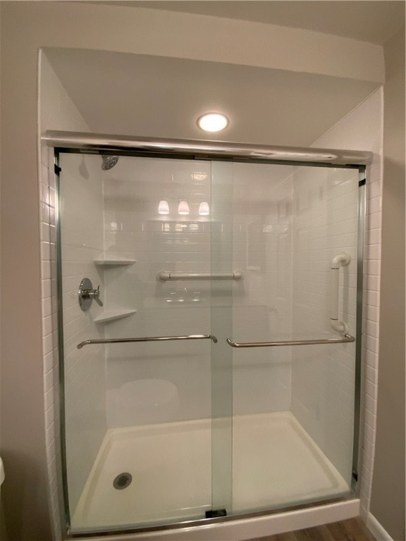 bathroom featuring hardwood / wood-style flooring and a shower with shower door