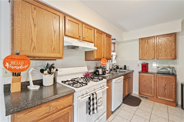 kitchen featuring sink, backsplash, crown molding, white appliances, and light tile patterned floors