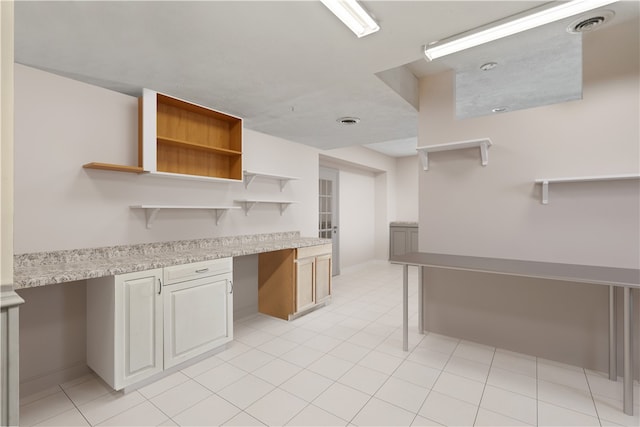 kitchen featuring light tile patterned floors and built in desk