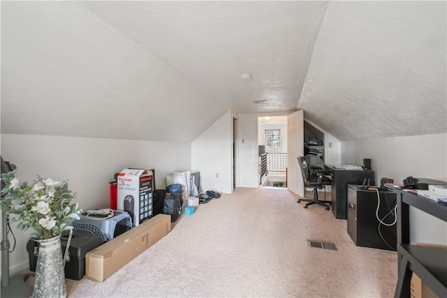 office space featuring a textured ceiling, carpet floors, and vaulted ceiling