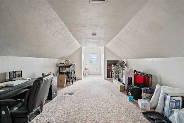 carpeted office featuring vaulted ceiling and a textured ceiling