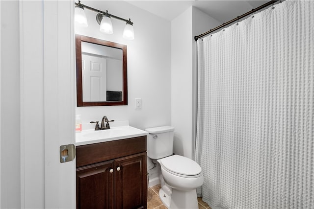 bathroom with toilet, vanity, and tile patterned floors