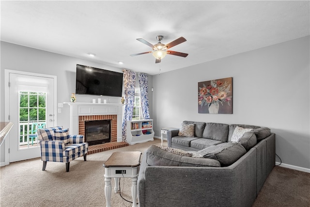 carpeted living room with a brick fireplace and ceiling fan