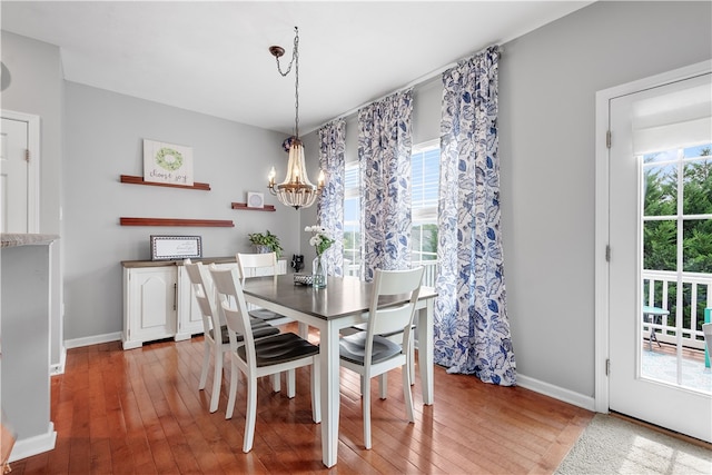 dining area featuring a chandelier, wood-type flooring, and plenty of natural light