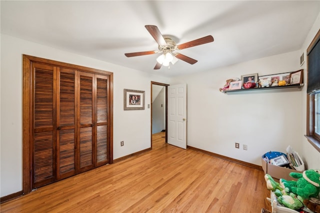 unfurnished bedroom with ceiling fan, a closet, and light wood-type flooring