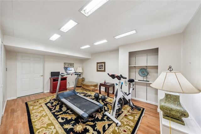 exercise room with light hardwood / wood-style floors