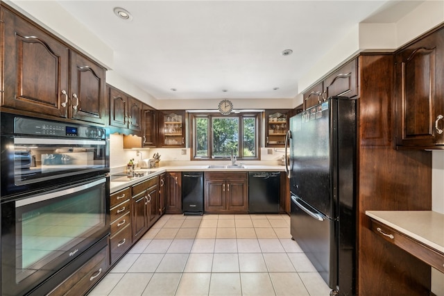 kitchen with dark brown cabinets, sink, light tile patterned floors, and black appliances