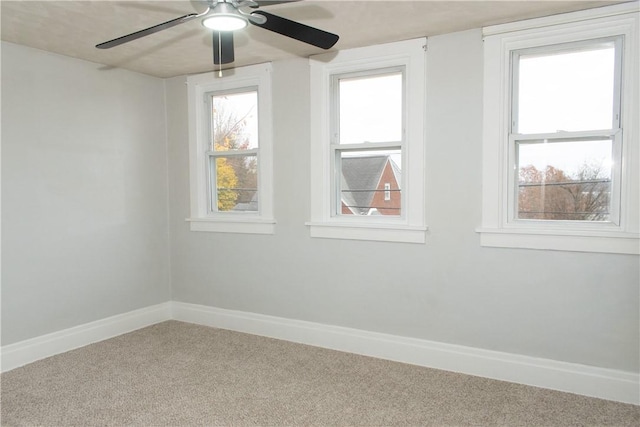 carpeted spare room with ceiling fan and a wealth of natural light