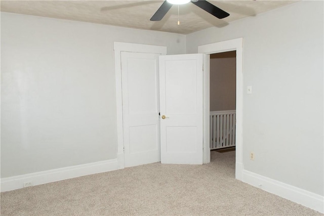 unfurnished room with ceiling fan and light carpet