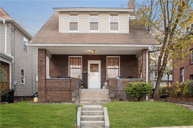 view of front of home with a porch and a front lawn