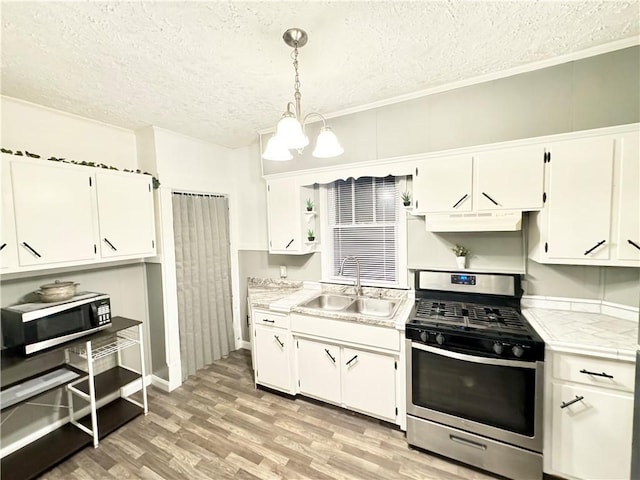 kitchen with white cabinetry, sink, an inviting chandelier, decorative light fixtures, and appliances with stainless steel finishes