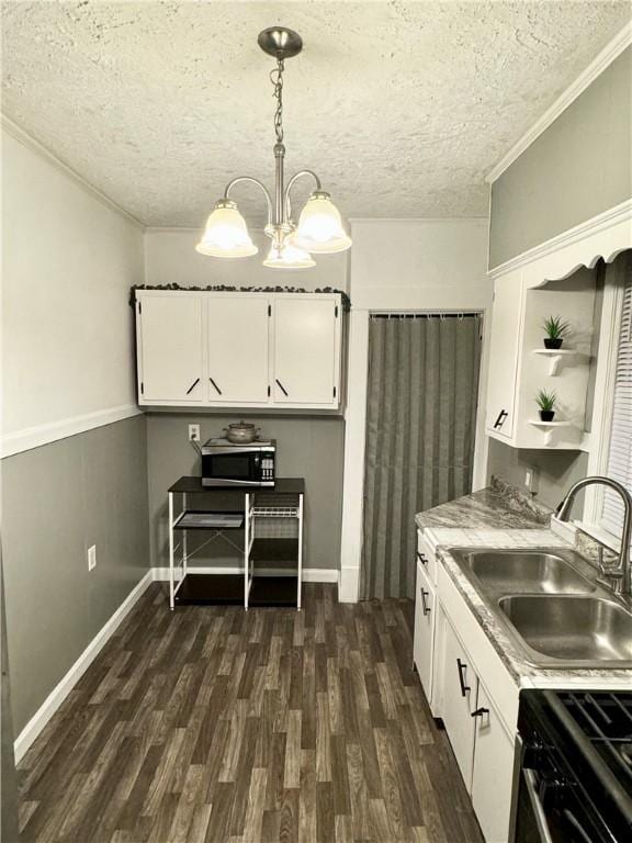 kitchen featuring a textured ceiling, sink, decorative light fixtures, an inviting chandelier, and white cabinets