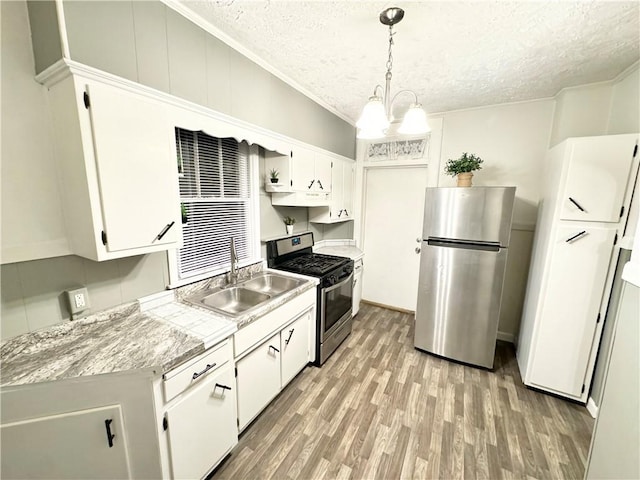 kitchen with pendant lighting, sink, white cabinets, and stainless steel appliances