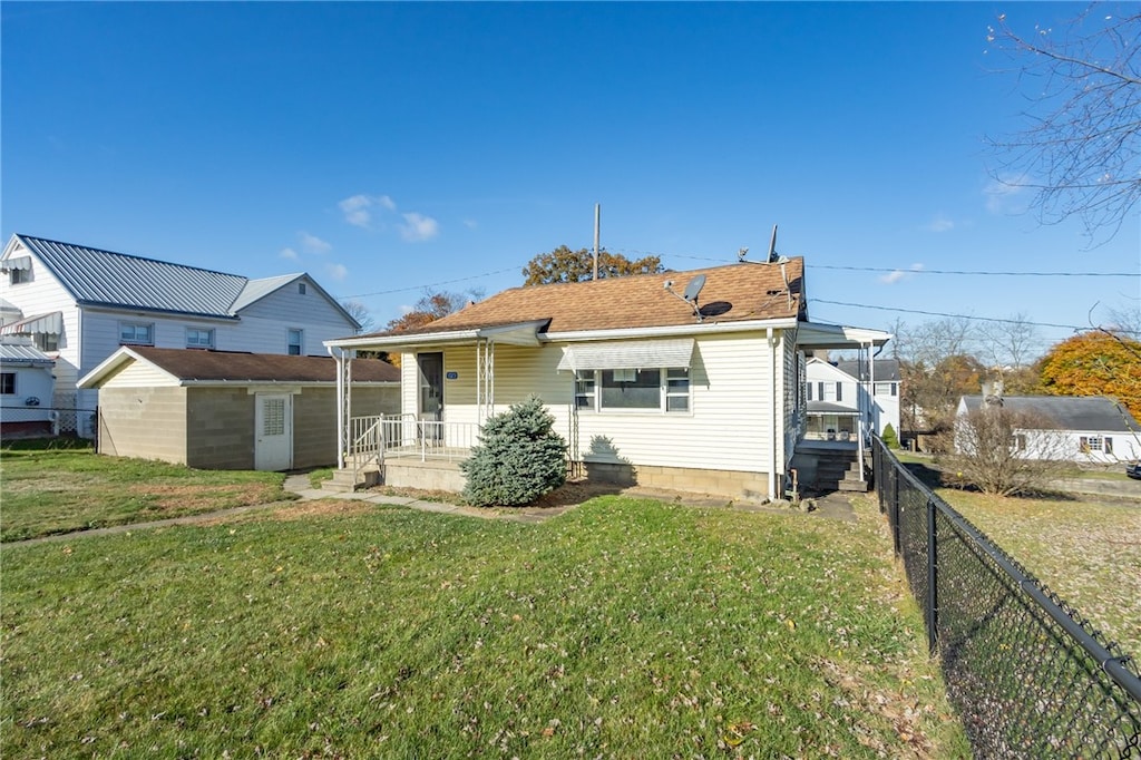 rear view of property featuring covered porch and a lawn