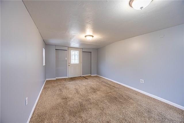 empty room featuring carpet and a textured ceiling