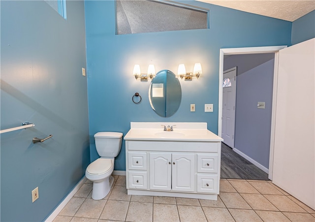 bathroom featuring tile patterned floors, vanity, vaulted ceiling, and a textured ceiling