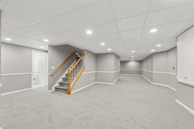 basement featuring carpet and a paneled ceiling