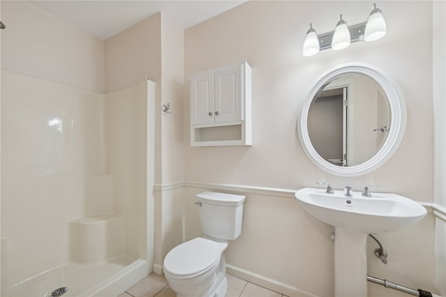 bathroom with tile patterned floors, sink, toilet, and a shower