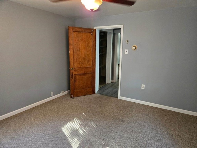 unfurnished bedroom featuring ceiling fan and dark carpet