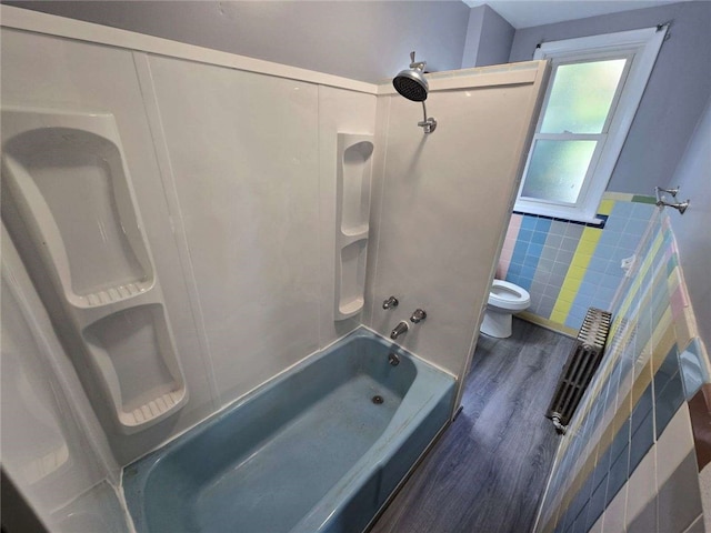 bathroom featuring shower / tub combination, hardwood / wood-style floors, tile walls, and toilet