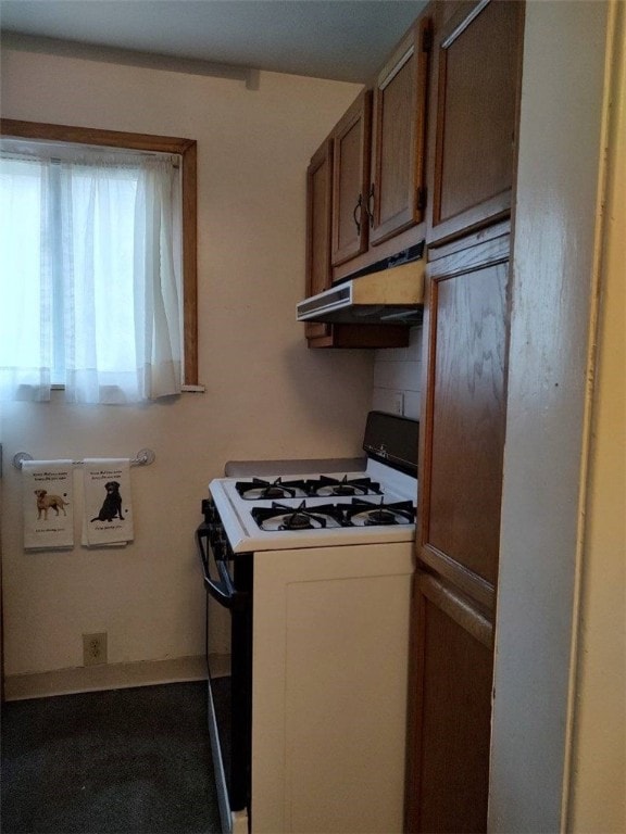 kitchen featuring backsplash and white gas range