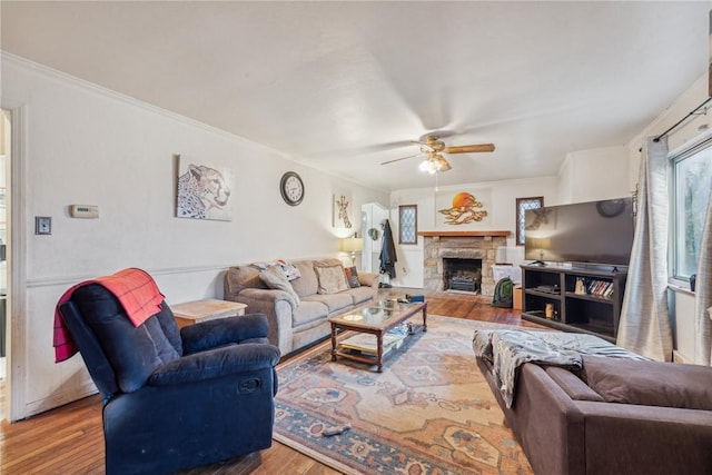 357 E Mcmurray Rd, Peters Twp, PA 15317 - living area with wood finished floors, ceiling fan, a stone fireplace, and crown molding