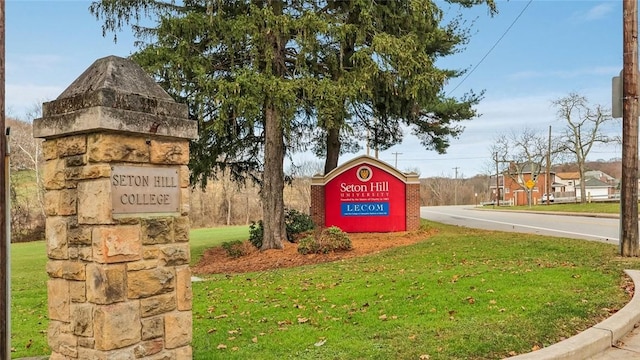 community / neighborhood sign featuring a yard