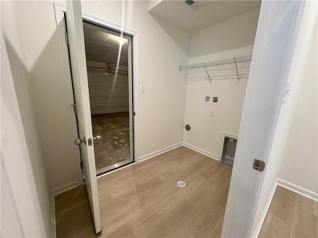 clothes washing area featuring hookup for an electric dryer, hookup for a washing machine, and light hardwood / wood-style flooring