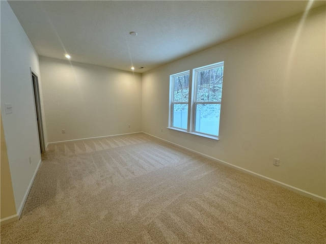 unfurnished room featuring light colored carpet