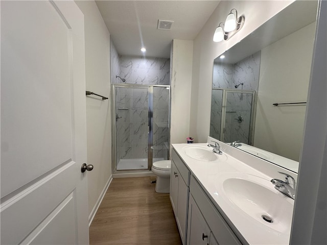 bathroom with hardwood / wood-style flooring, vanity, toilet, and walk in shower