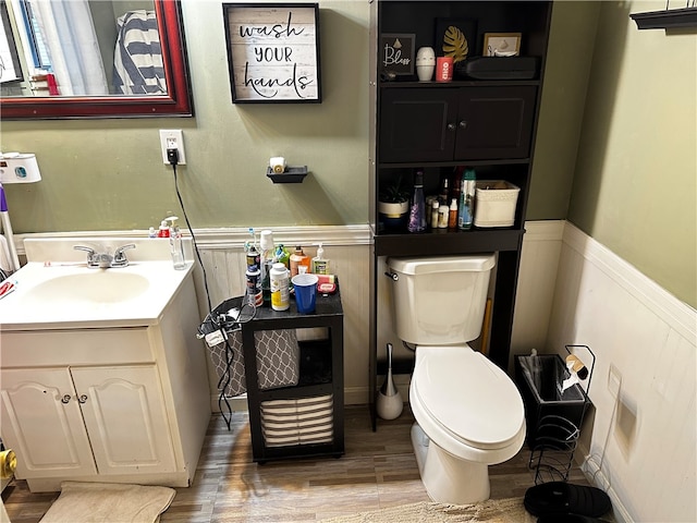 bathroom featuring vanity, wood-type flooring, and toilet