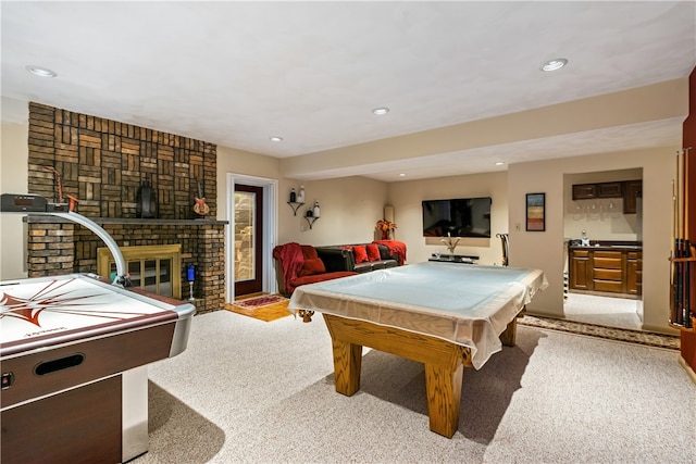 rec room featuring light carpet, a brick fireplace, and pool table