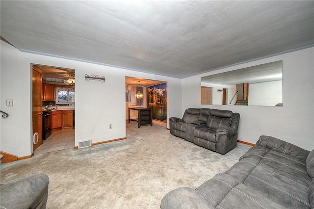 living room with light carpet, a textured ceiling, and ceiling fan