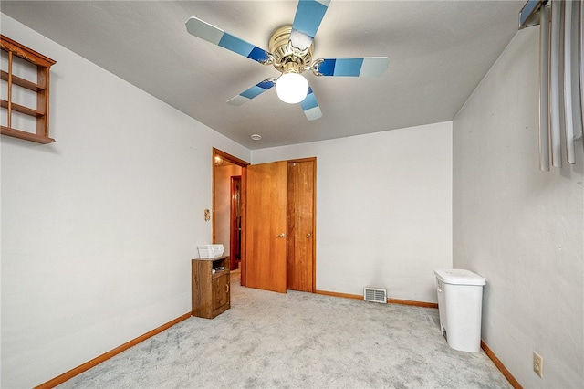 unfurnished bedroom featuring light colored carpet and ceiling fan