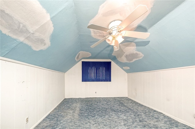 bonus room featuring wooden walls, carpet floors, and vaulted ceiling